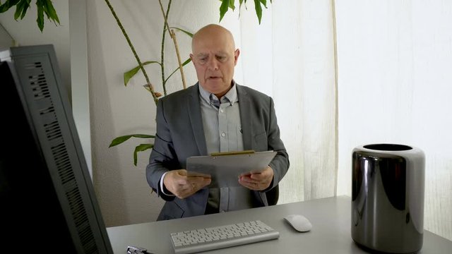 Boss Angrily Reading Performance Report Document in Office