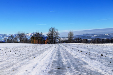 Fototapeta na wymiar Frozen forest road sprinkled with gravel in foothills of Beskydy mountains in Czech republic. Typical winter day. Countryside view. Gorgeous snow cover.