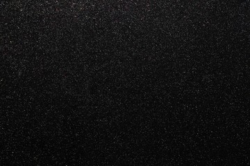 Fototapeta premium Black glitters abstract shiny background. Design paper texture for decoration and design of Christmas, New Year or other holiday pictures. Beautiful packaging material.