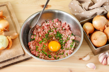 Mixing meat and eggs to prepare the meatballs.