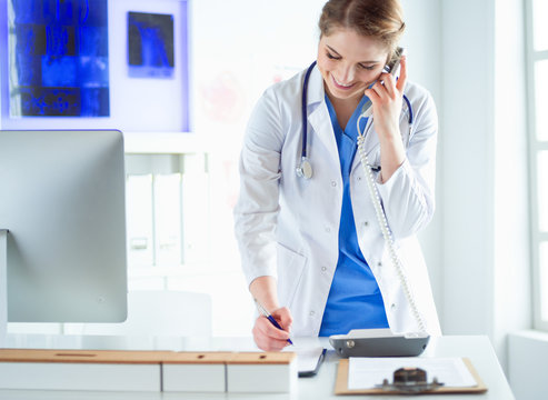 Serious Doctor On The Phone In Her Office