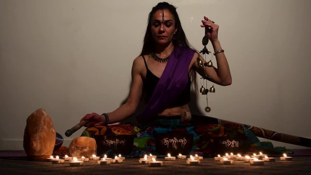 A woman master of Asian sacred medicine performs Tibetan bowls healing ritual. Meditation with Tibetan singing bowls.
