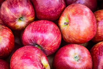 Close-up of shiny red juicy ripe apple fruits at the fruit market, healthy natural food.