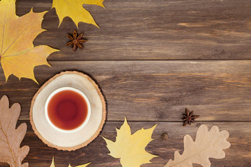 Hot tea on round tray, frame from spices, autumn leaves on wooden background. Recipe, hot beverage concept. Top view, flat lay, copy space, mock up, layout design