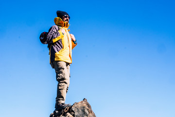 People enjoying the outdoor leisure ativity with sport hiking lifestyle - man standing on the top of the mountains looking at the blue sky - clear background success and travel concept