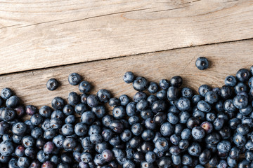 Delicious blueberries on wooden background with copyspace. Top view