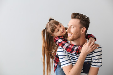 Portrait of happy father and daughter on light background