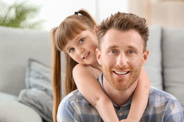 Fototapeta premium Portrait of happy father and his little daughter at home