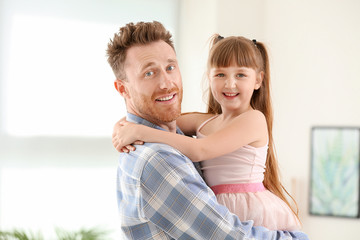 Portrait of happy father and his little daughter at home