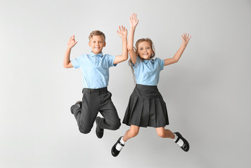 Jumping little pupils on light background