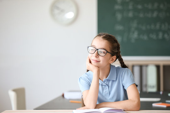 Cute little girl during lesson in classroom