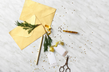 Envelopes with tags, scissors and decor on light background