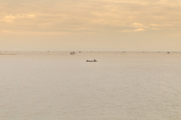 Soft ocean waves and bubbles on the beach with a sunset sky background
