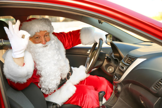 Santa Claus showing OK gesture while driving car