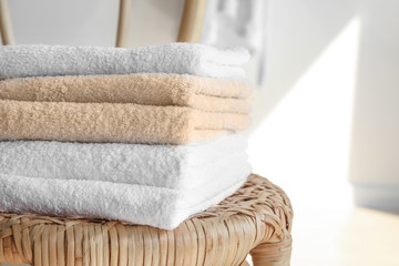 Stack of clean soft towels on chair in room, closeup