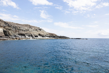 Fototapeta na wymiar Ocean littoral with cliffs and cloudy sky