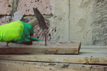 Worker hammering a nail into  wood