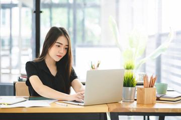 Young Asian graphic designer working on computor and graphics tablet in her working space