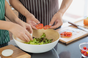 Young Asian couple preparing vegetable for make a fresh salad for their lunch