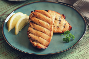 Grilled chicken breast on wooden background