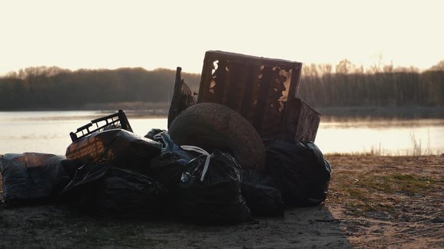 Lots of garbage, old stuff, on the beach at sunset. Environmental pollution.