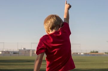 Niño celebrando un gol en un campo de hierba