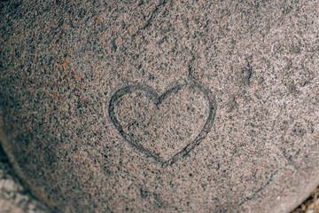 Heart sign carved on a stone. Sign of love on granite. Stone engraving