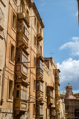 Fototapeta premium street with traditional balconies and old buildings in historical city Valletta Malta