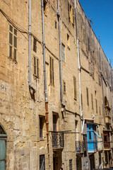 Fototapeta na wymiar street with traditional balconies and old buildings in historical city Valletta Malta