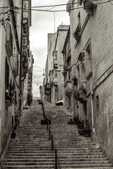 Naklejka premium street with traditional balconies and old buildings in historical city Valletta Malta