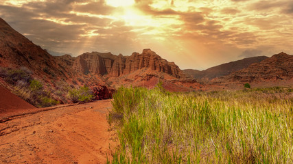 fantastic clay castles in the sandy desert of the red canyon Konorchek, in Kyrgyzstan in the rays...
