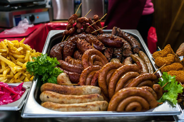 Assortment hot grilled sausages and fried potatoes cooked