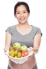 A portrait of a Happy pregnant woman with a bowl of fruits