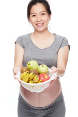 A portrait of a Happy pregnant woman with a bowl of fruits