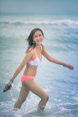 beautiful asian younger woman wearing bikini  on sea beach with smiling face
