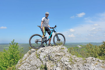 Zborów Mountain, Poland. Man on top of a mountain on a bike. - obrazy, fototapety, plakaty