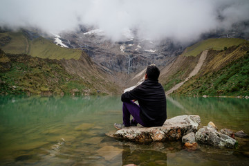 Fototapeta na wymiar man in front of the Humantay Lake on the Salkantay Trail, the trek to Machu Picchu, Peru
