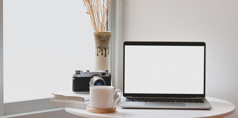 Trendy photographer workplace with open blank screen laptop
