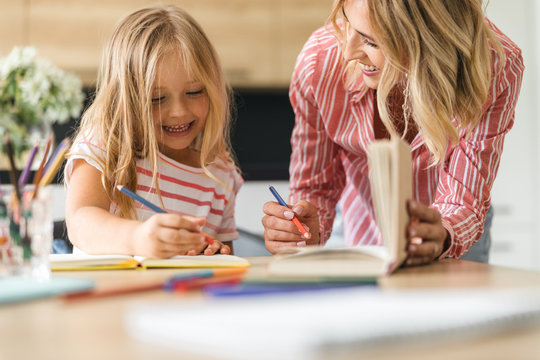 Mother and daughter drawing and smiling stock photo
