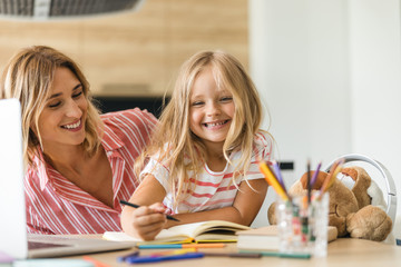 Fototapeta premium Mother smiling when her daughter drawing stock photo