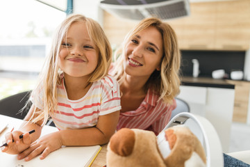 Girl sitting with mother and smiling stock photo