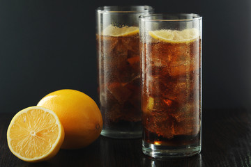 Glasses with cuba libre cocktail or cola with ice or cold tea with lemon