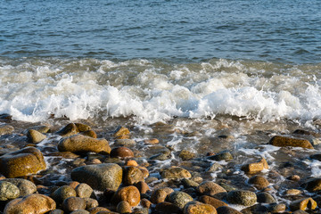 Vague qui s'écrase sur des galets