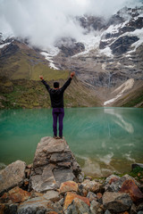 man in front of the Humantay Lake on the Salkantay Trail, the trek to Machu Picchu, Peru