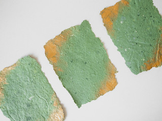 photo of handmade psper green color with gold corners on the white table for mockup design of wedding invitation