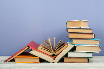 Open book, hardback colorful books on wooden table. Back to school. Copy space for text. Education business concept.