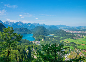 Fototapeta na wymiar Beautiful summer day in bavarian Alps with a view to Alpsee lake and Neuschwanstein castle Germany from hiking trail 