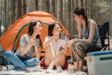 Groupe de jeunes amis asiatiques campant ou pique-niquant ensemble dans la forêt, les adolescentes profitent d& 39 un moment pour parler devant leur tente. Les femmes font des activités d& 39 aventure et voyagent en vacances en été.