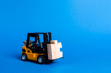 Forklift truck carries part of the puzzle. Business processes and globalization concept. Take a Niche Market. Take part in a large project or economic process. investment. Startup, crowdfunding.