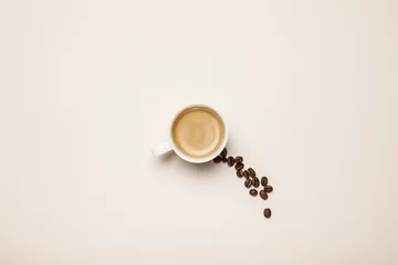 Crédence de cuisine en verre imprimé Bar a café vue de dessus de la tasse avec un café savoureux près des grains de café sur fond beige